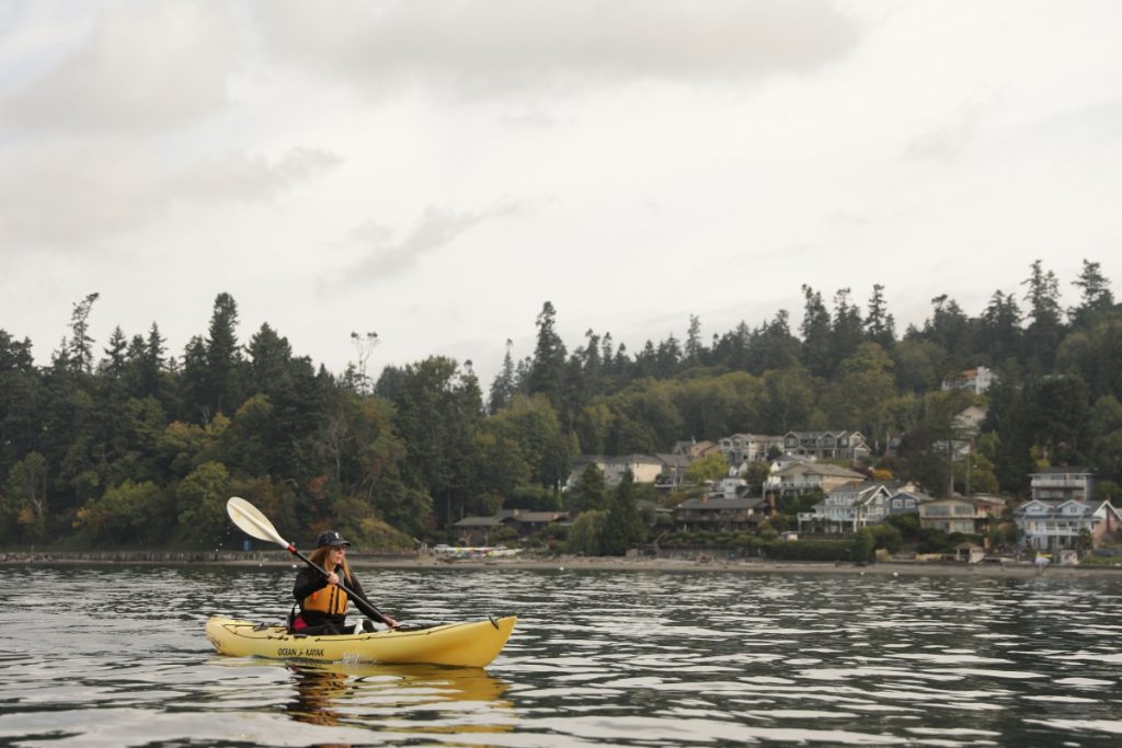 Kayaking by the homes of Des Moines, Washington in Puget Sound