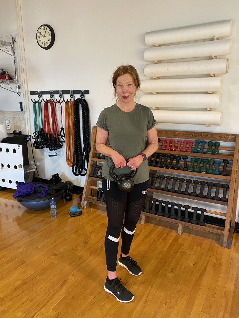 woman in Size Up reflective joggers holding kettlebell