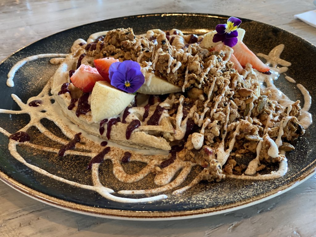 Vegan waffle topped with edible flowers